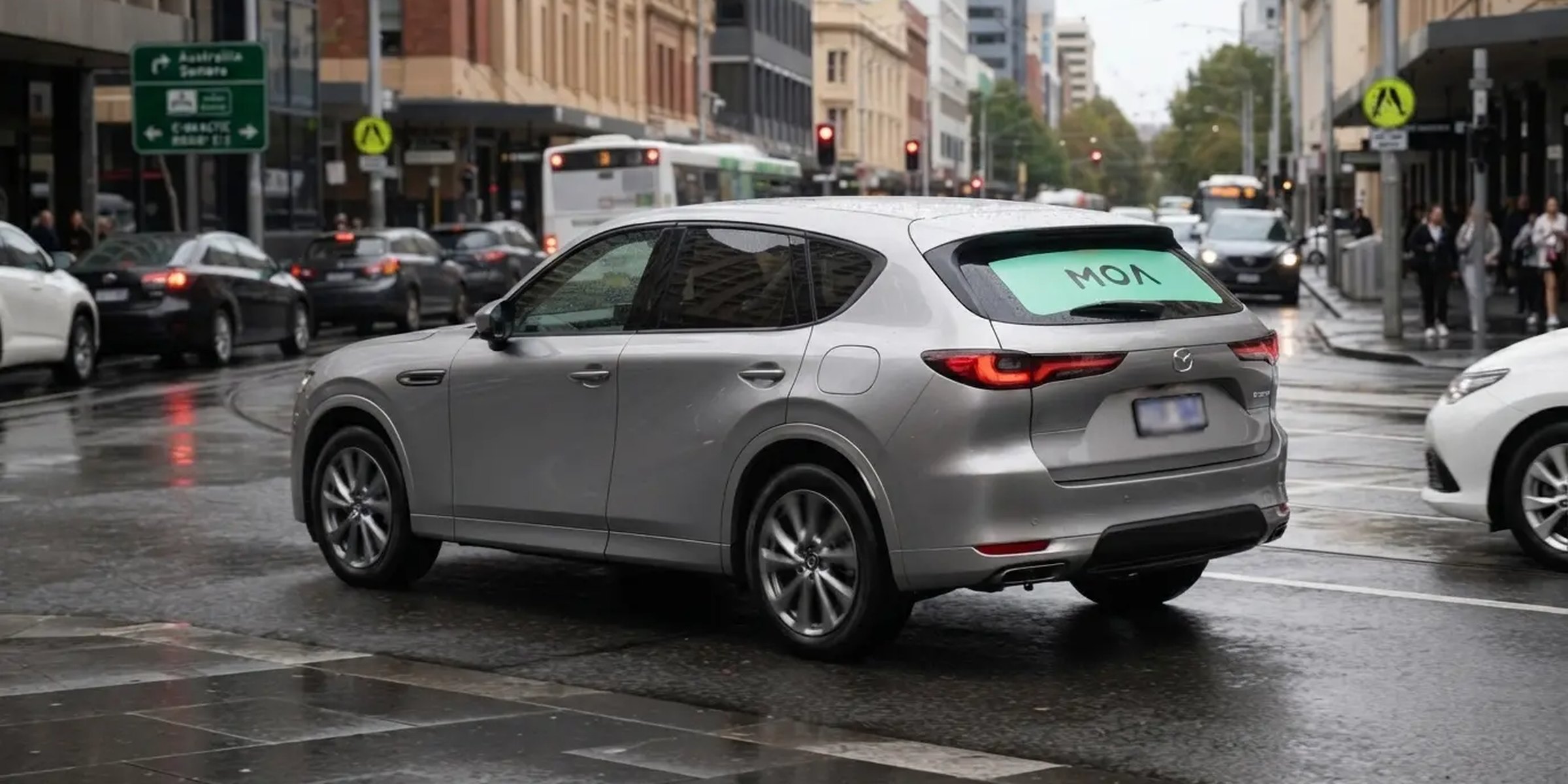 MOA branded SUV in wet Adelaide city traffic, mint rear window ad visible