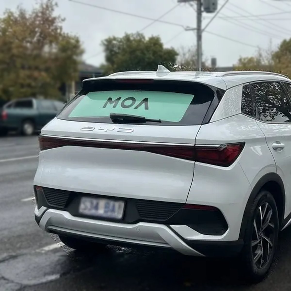 Suburban streets: MOA branded white SUV on a quiet residential road