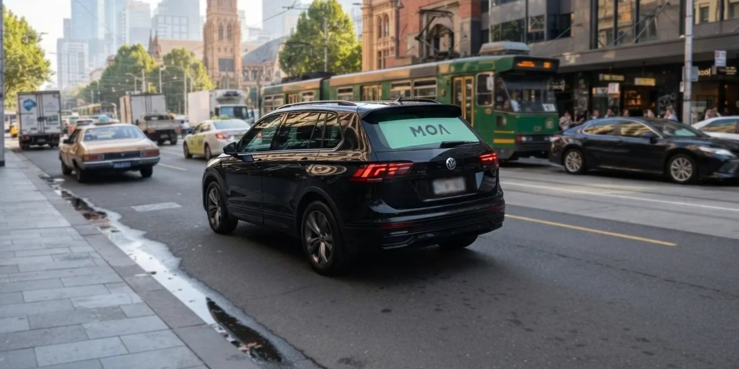 MOA branded SUV in city traffic, mint rear window ad visible