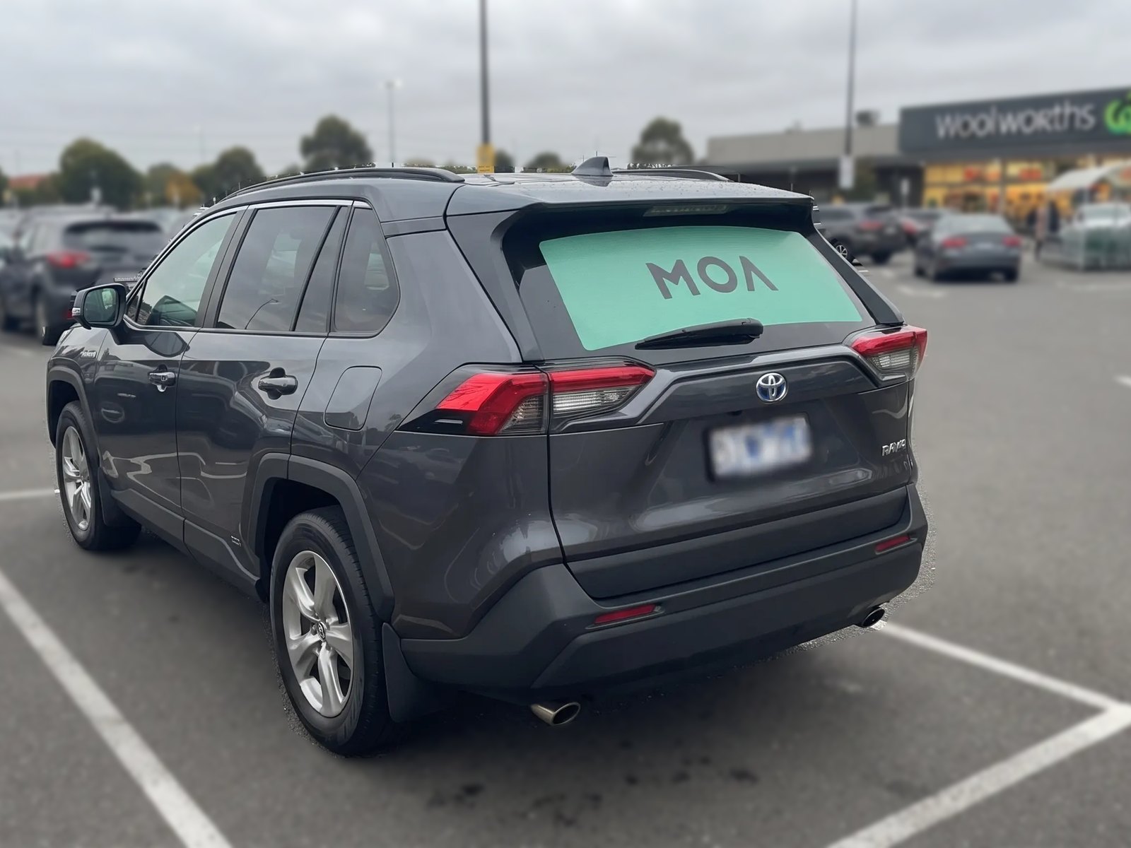 MOA branded SUV parked at a suburban shopping centre, an ordinary trip carrying an ad