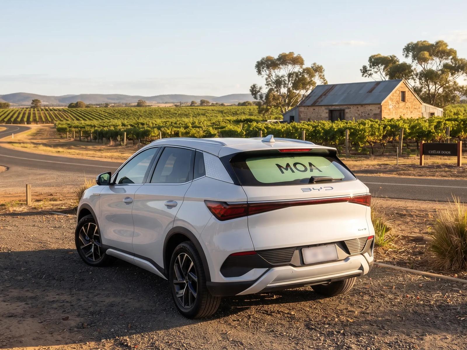 MOA branded electric SUV parked on a country road at golden hour, mint rear window ad visible